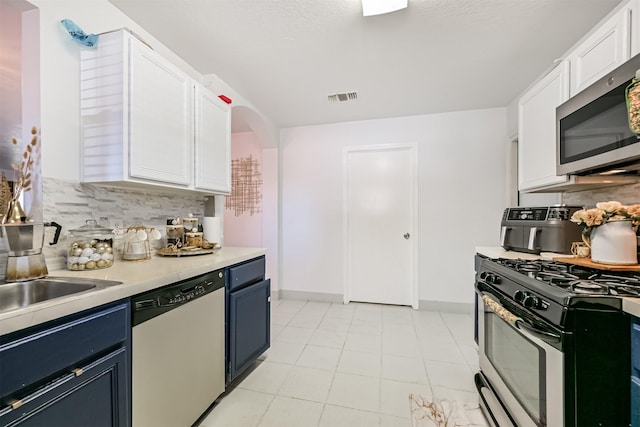 kitchen featuring visible vents, white cabinets, light countertops, appliances with stainless steel finishes, and backsplash