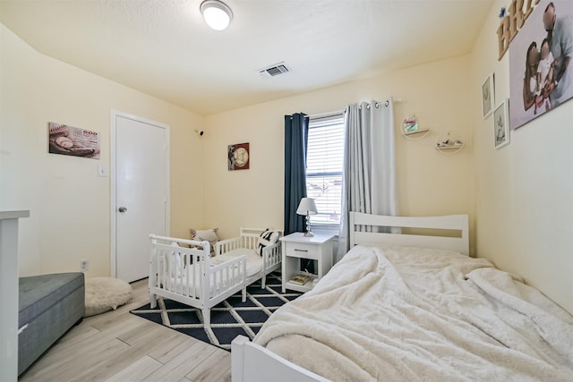 bedroom featuring wood finished floors and visible vents