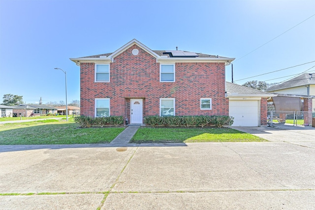 view of front of house with a garage, solar panels, brick siding, driveway, and a front yard