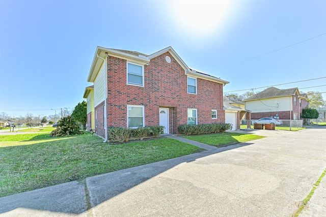 view of front of house featuring a garage, brick siding, driveway, and a front lawn