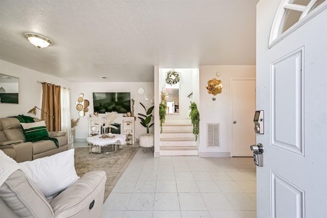 living area featuring stairway and visible vents