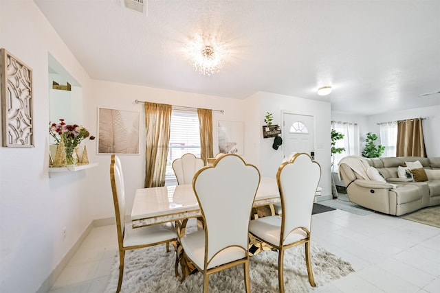 dining space featuring baseboards, visible vents, and a healthy amount of sunlight