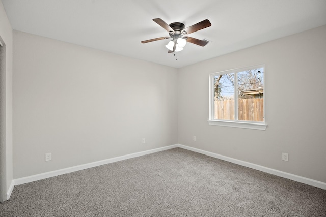 carpeted empty room with a ceiling fan and baseboards