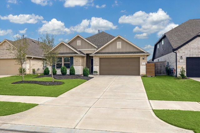 craftsman house with a garage, driveway, roof with shingles, a front lawn, and board and batten siding