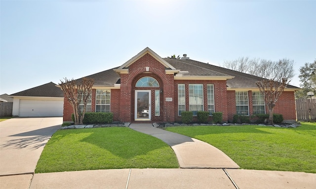 single story home with a shingled roof, a front yard, brick siding, and driveway