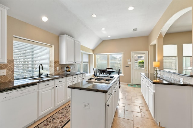 kitchen featuring a center island, stainless steel gas cooktop, stone tile floors, a sink, and dishwasher