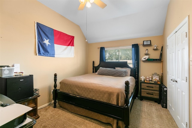 bedroom featuring a ceiling fan, lofted ceiling, a closet, and carpet