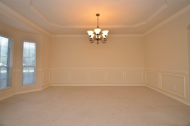 unfurnished room with a tray ceiling, light colored carpet, and an inviting chandelier