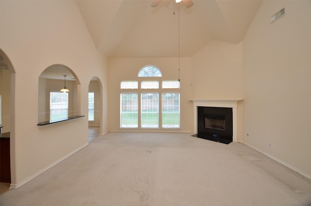 unfurnished living room with high vaulted ceiling, baseboards, and ceiling fan