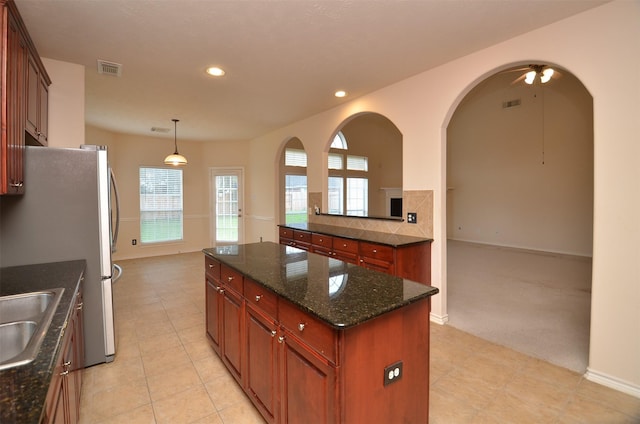 kitchen featuring recessed lighting, visible vents, freestanding refrigerator, and a center island