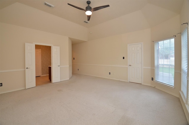 interior space with visible vents, light carpet, high vaulted ceiling, and baseboards