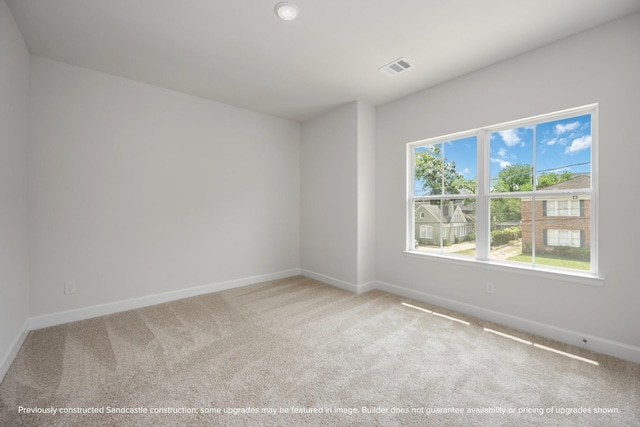 carpeted empty room featuring visible vents and baseboards