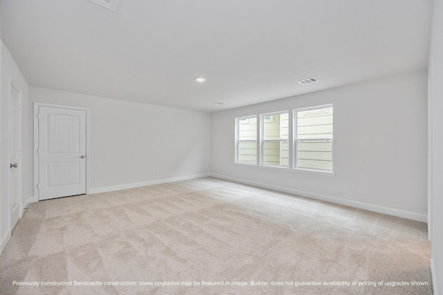 spare room featuring carpet, visible vents, and baseboards