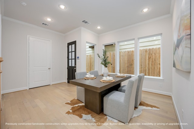 dining space with visible vents, crown molding, and light wood finished floors