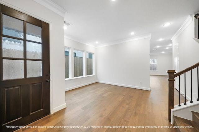 foyer with light wood-style floors, baseboards, stairway, and ornamental molding