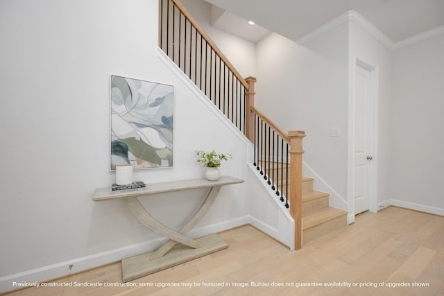 staircase with recessed lighting, crown molding, baseboards, and wood finished floors