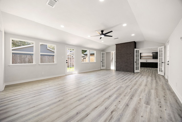 unfurnished living room featuring lofted ceiling, french doors, visible vents, and light wood-style flooring