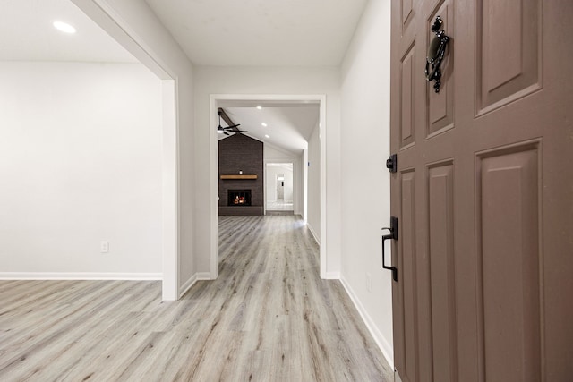 hall featuring recessed lighting, light wood-style floors, baseboards, and lofted ceiling
