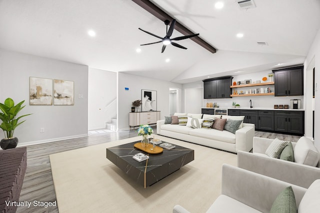 living area featuring visible vents, stairway, vaulted ceiling with beams, light wood-style floors, and indoor wet bar