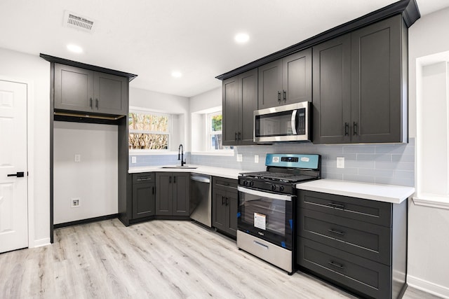 kitchen featuring tasteful backsplash, visible vents, stainless steel appliances, and a sink