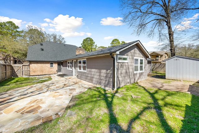 back of property with a chimney, a patio area, a fenced backyard, and an outdoor structure