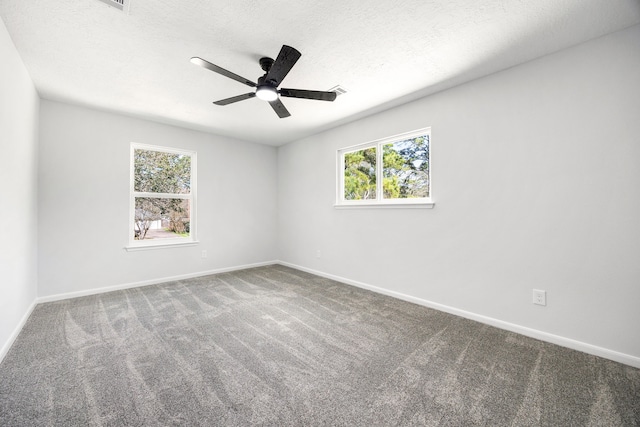 carpeted empty room with ceiling fan, baseboards, and a textured ceiling