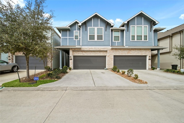 view of front of home featuring a garage, stone siding, and concrete driveway