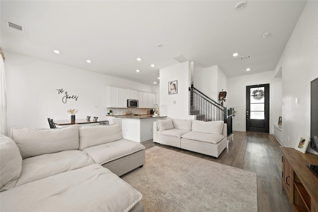 living area featuring stairway, visible vents, wood finished floors, and recessed lighting