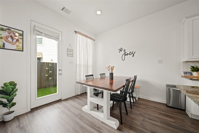 dining space with dark wood finished floors, visible vents, and baseboards