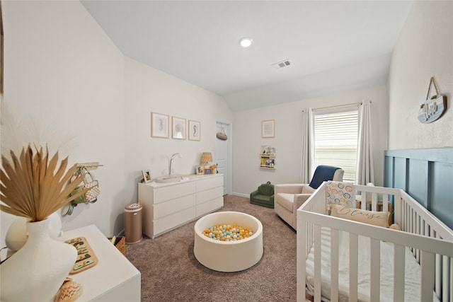 carpeted bedroom with a nursery area, visible vents, lofted ceiling, and baseboards