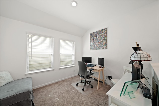 carpeted office featuring vaulted ceiling and baseboards