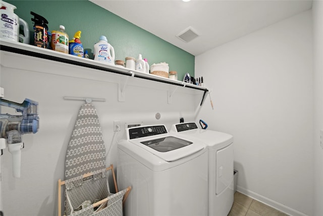 washroom with light tile patterned flooring, laundry area, visible vents, baseboards, and washer and clothes dryer