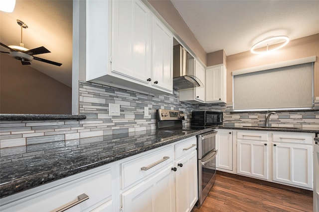 kitchen with double oven range, black microwave, white cabinets, and a sink