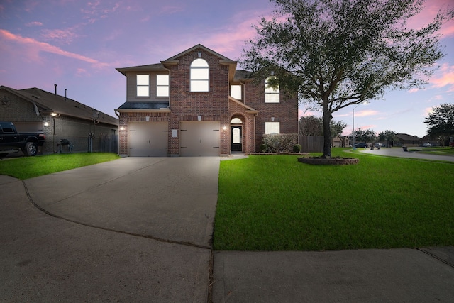 traditional home featuring a garage, driveway, fence, a front lawn, and brick siding