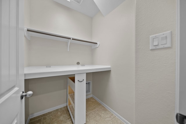 laundry area with laundry area, baseboards, and tile patterned floors