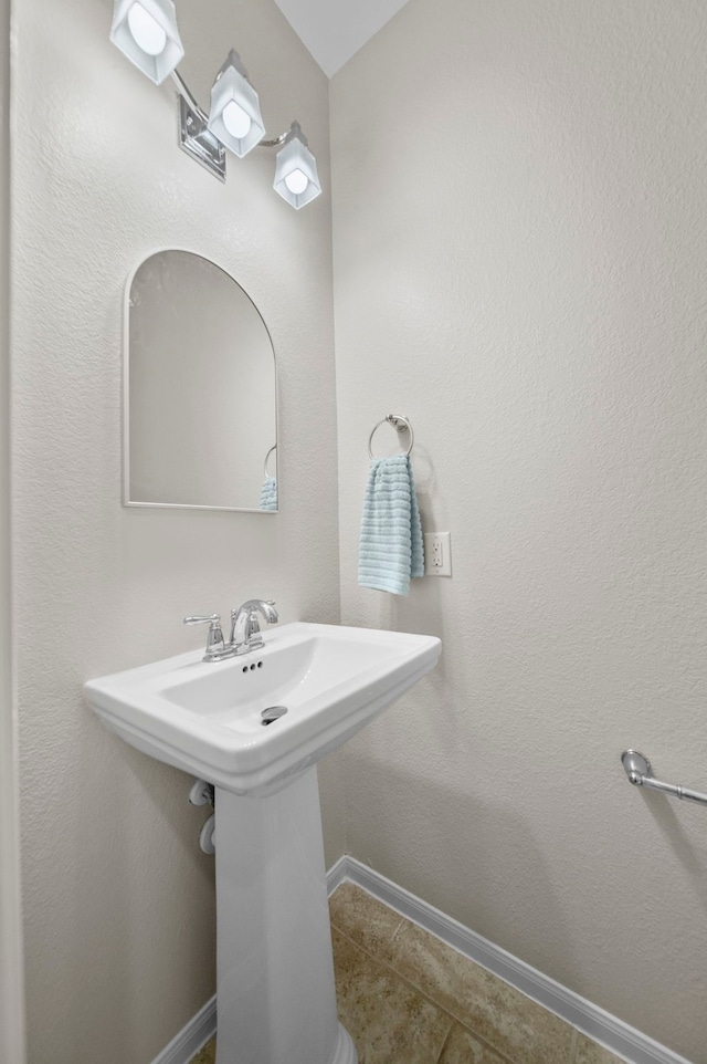 bathroom with baseboards and tile patterned floors