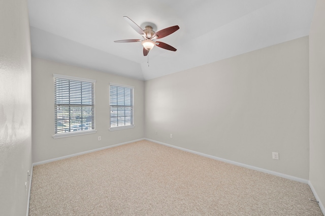 empty room with a ceiling fan, baseboards, vaulted ceiling, and carpet flooring