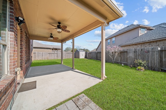 view of patio with a shed, ceiling fan, a fenced backyard, and an outbuilding