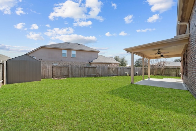 view of yard featuring a ceiling fan, a fenced backyard, a patio, and an outdoor structure