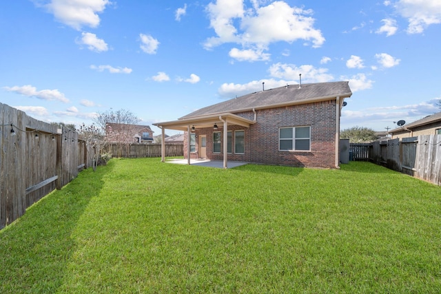 rear view of property featuring a yard, a fenced backyard, a patio, and brick siding