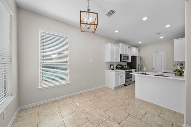 kitchen with white cabinets, stainless steel appliances, light countertops, a sink, and recessed lighting