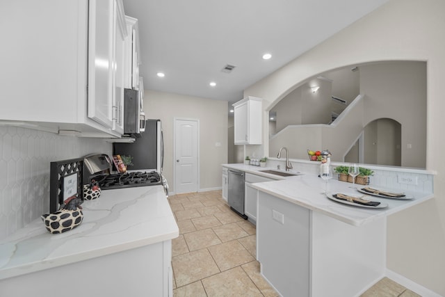 kitchen featuring stainless steel appliances, visible vents, a sink, and white cabinetry