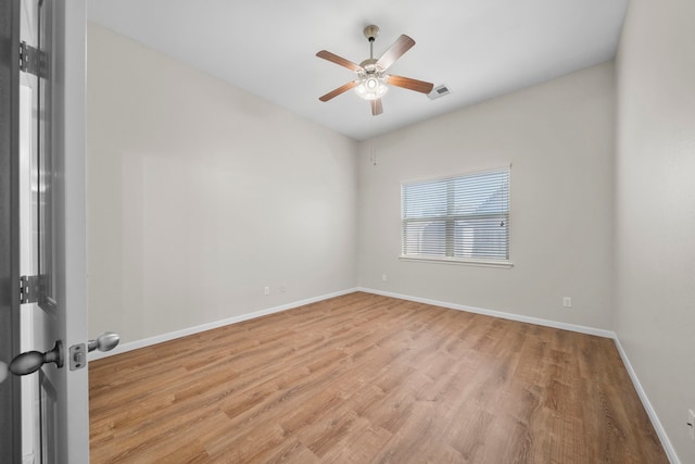 unfurnished room featuring ceiling fan, visible vents, baseboards, and wood finished floors