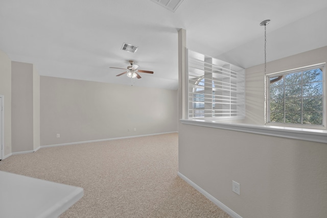 carpeted empty room featuring a ceiling fan, visible vents, and baseboards