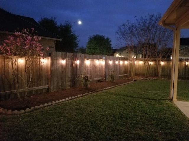 yard at twilight with a fenced backyard