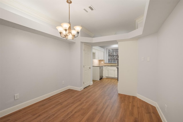 unfurnished dining area with a chandelier, baseboards, visible vents, and light wood finished floors