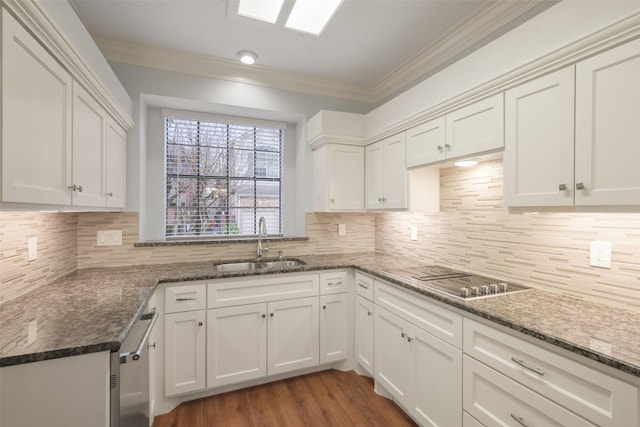 kitchen with white cabinets, a sink, black electric cooktop, and crown molding