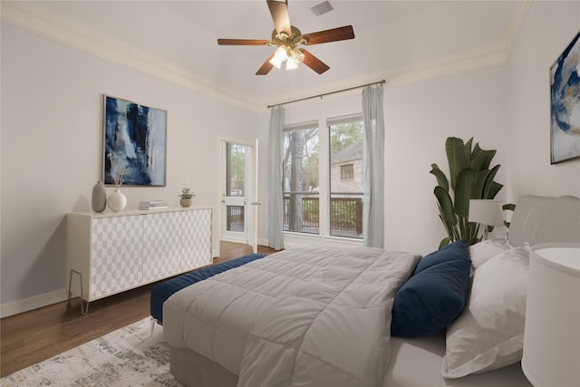 bedroom featuring ornamental molding, wood finished floors, visible vents, and baseboards