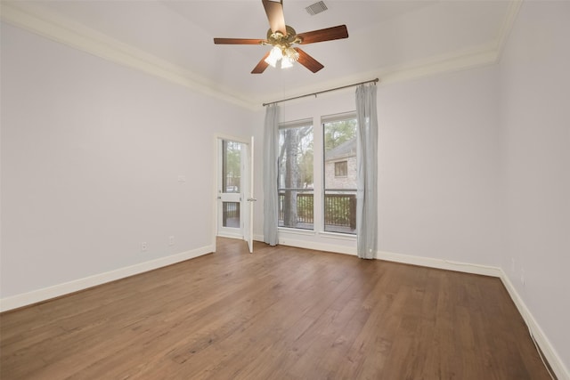 spare room with baseboards, wood finished floors, and ornamental molding