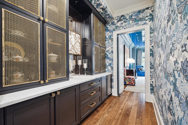 bar with hardwood / wood-style flooring, crown molding, baseboards, and wallpapered walls